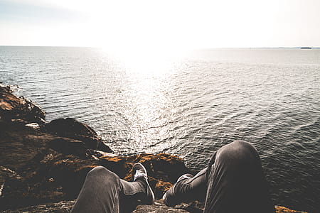Photo of Person Sitting on Cliff thumbnail