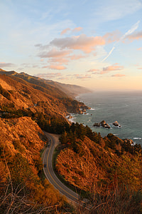 three cars on concrete pavement beside mountain thumbnail