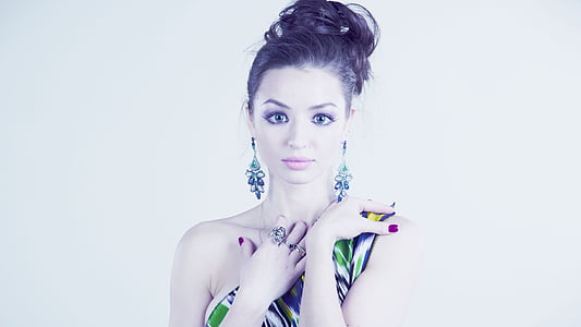 woman wearing pair of silver-colored pendant earrings thumbnail