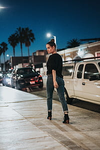 woman walking near white pickup truck during nighttime thumbnail