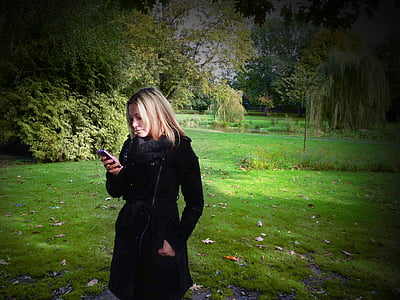 woman inserting her left hand on black coat pocket outdoors thumbnail