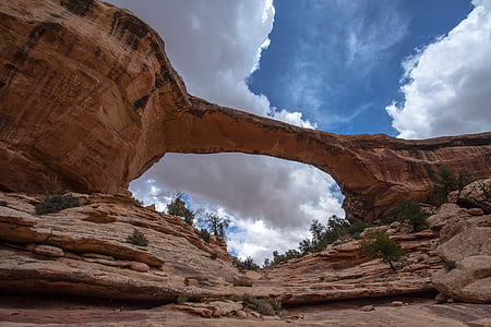 worm's-eye view of rock formation under cloudy sky thumbnail