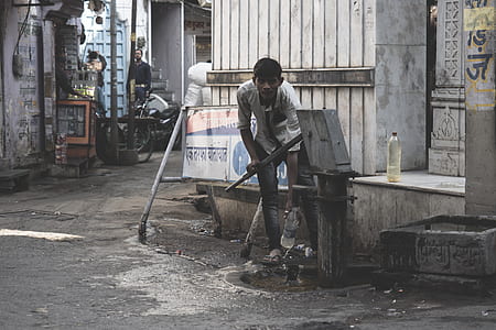 man using brown manual water pump filling water thumbnail