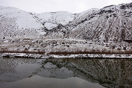 glassy body of water with reflection of snow-covered mountain at daytime thumbnail