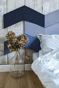 Designer bedroom with an ornamental golden plant in a jar by the bed thumbnail