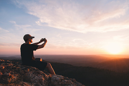 photography of man taking photo of sun thumbnail