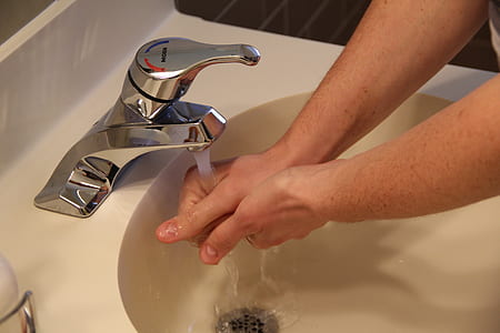 person washing hands on faucet thumbnail