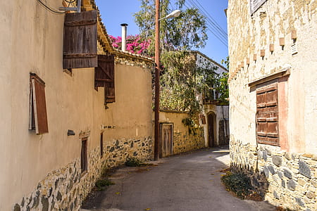 gray pathway between brown houses thumbnail