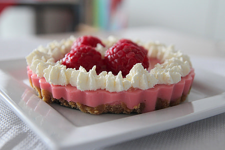 close-up photo of raspberry tart with cream toppings on white ceramic tray thumbnail