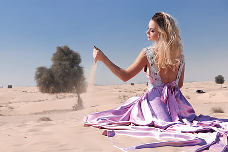 woman wearing purple dress playing with sand thumbnail
