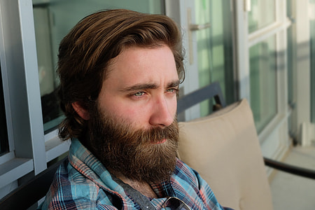 man wearing plaid dress shirt sitting on black metal bench thumbnail