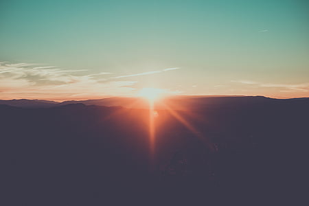 silhouette of mountain with sun lens flare thumbnail