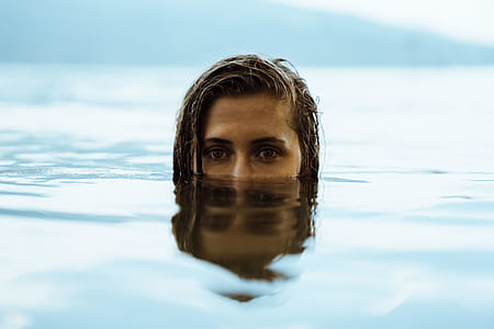 woman submerged in body of water during daytime thumbnail