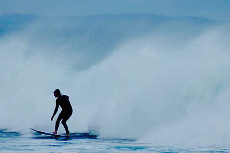 silhouette of man surfing in body of water thumbnail