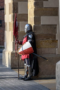 Man Wearing Gray and Red Armour Standing on the Streets thumbnail
