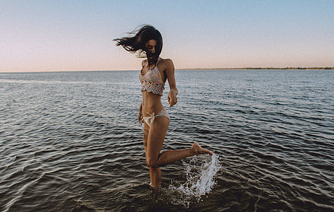 woman standing beside body of water thumbnail