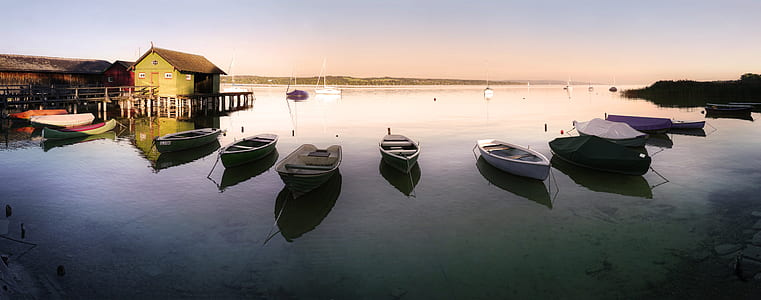assorted-color boats near house at daytime thumbnail