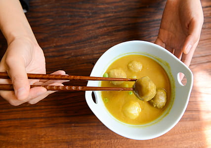 Person Holding Chopsticks and White Ceramic Bowl thumbnail
