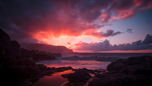 rock formation near seashore during sunset thumbnail