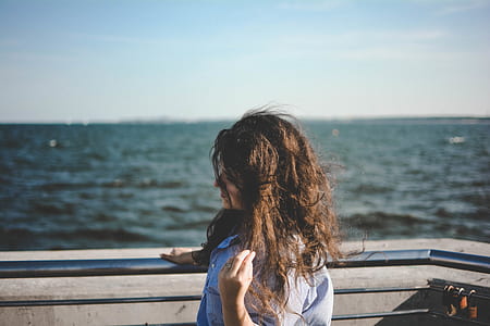 woman near body of water holding her hair thumbnail