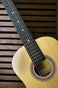 Brown Acoustic Guitar on Brown Wooden Board thumbnail
