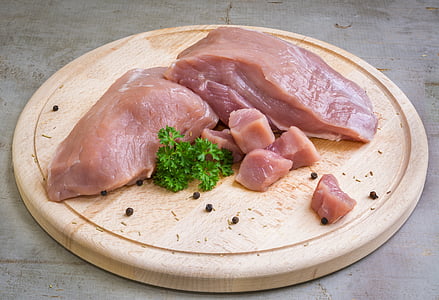 chicken breast and green parsley on round chopping board thumbnail