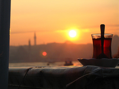 Turkish tea glass on top of saucer facing golden hour thumbnail