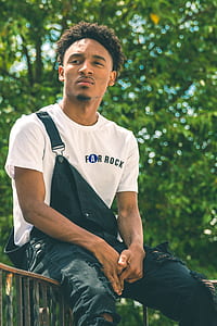man in white top sitting on bar thumbnail