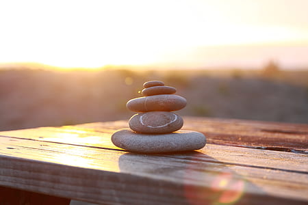 selective focus photograph of cairn on wooden surface thumbnail