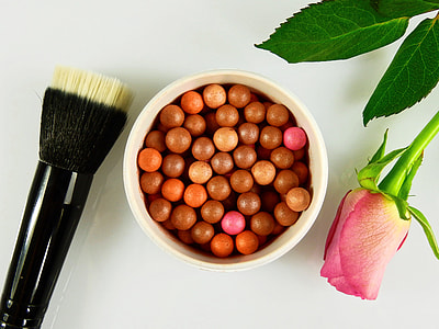 makeup brush and rose beside bronzer makeup thumbnail