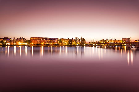 Brown Lighted Buildings Near the Body of Water Landscape Photo thumbnail