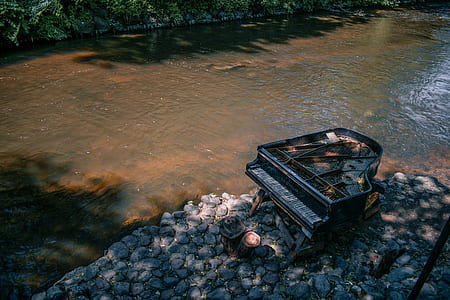 black grand piano beside body of water thumbnail