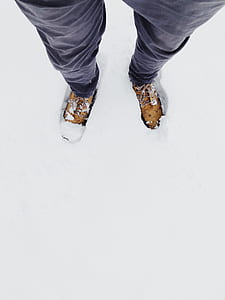 person wearing brown work boots standing on snow thumbnail
