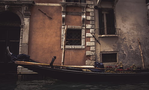 brown boat on body of water near building at daytime thumbnail