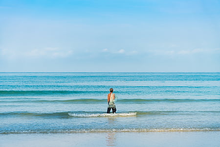 man standing near shoreline while water splashing thumbnail