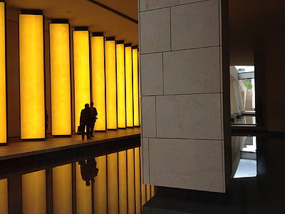 Silhouette Photo of 2 Person Beside Beige Concrete Lighted Wall thumbnail