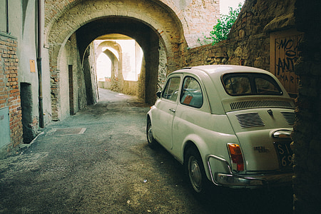 white coupe on narrow pathway during daytime thumbnail