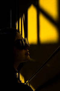 person in sunglasses looking at window thumbnail