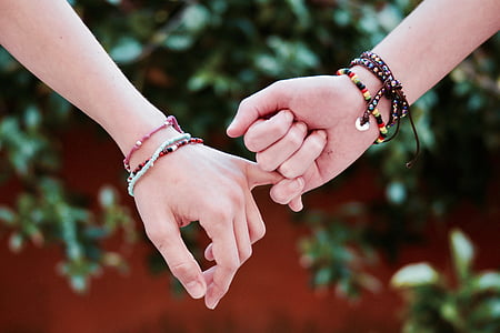 shallow focus of two person holding hands thumbnail