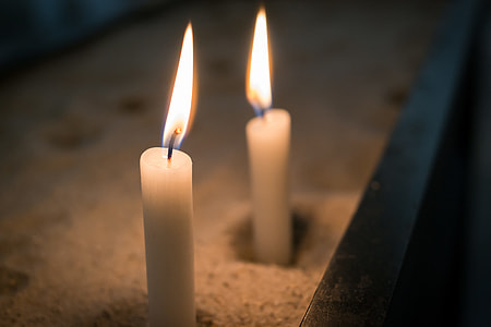 shallow focus photography of two white candles with light thumbnail