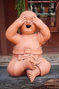 young budai statue on wooden surface thumbnail