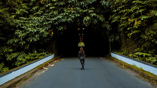 woman standing on pathway in front of tunnel thumbnail