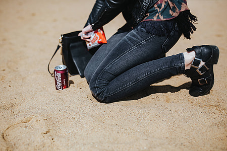 Young woman wearing a leather jacket and sunglasses on the beach thumbnail