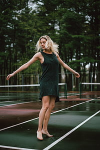 woman standing on green and maroon tennis court thumbnail