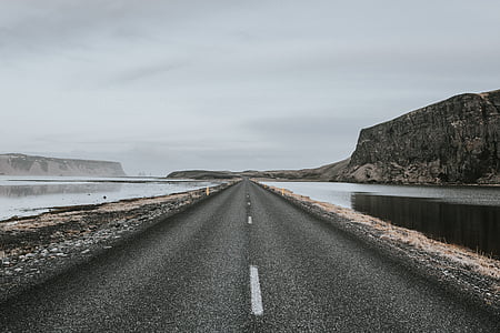 asphalt road near body of water and mountain thumbnail