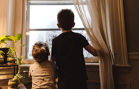 two boys looking outside glass window thumbnail