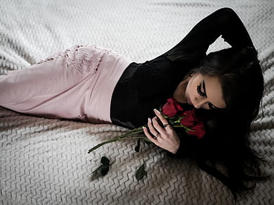 woman holding bunch of rose lying on bed thumbnail