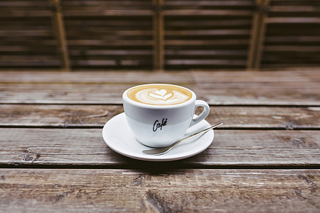 coffee with late art on top with teaspon on table thumbnail