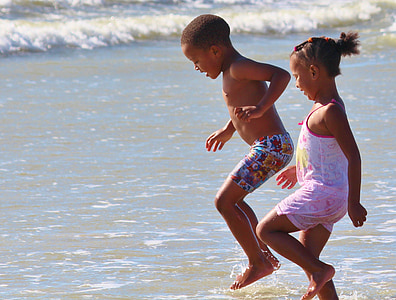 girl and boy playing on beach thumbnail