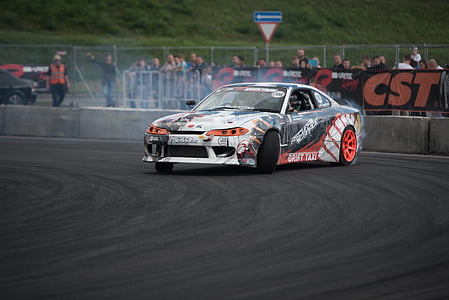 black and white coupe drifting on black concrete road at daytime thumbnail